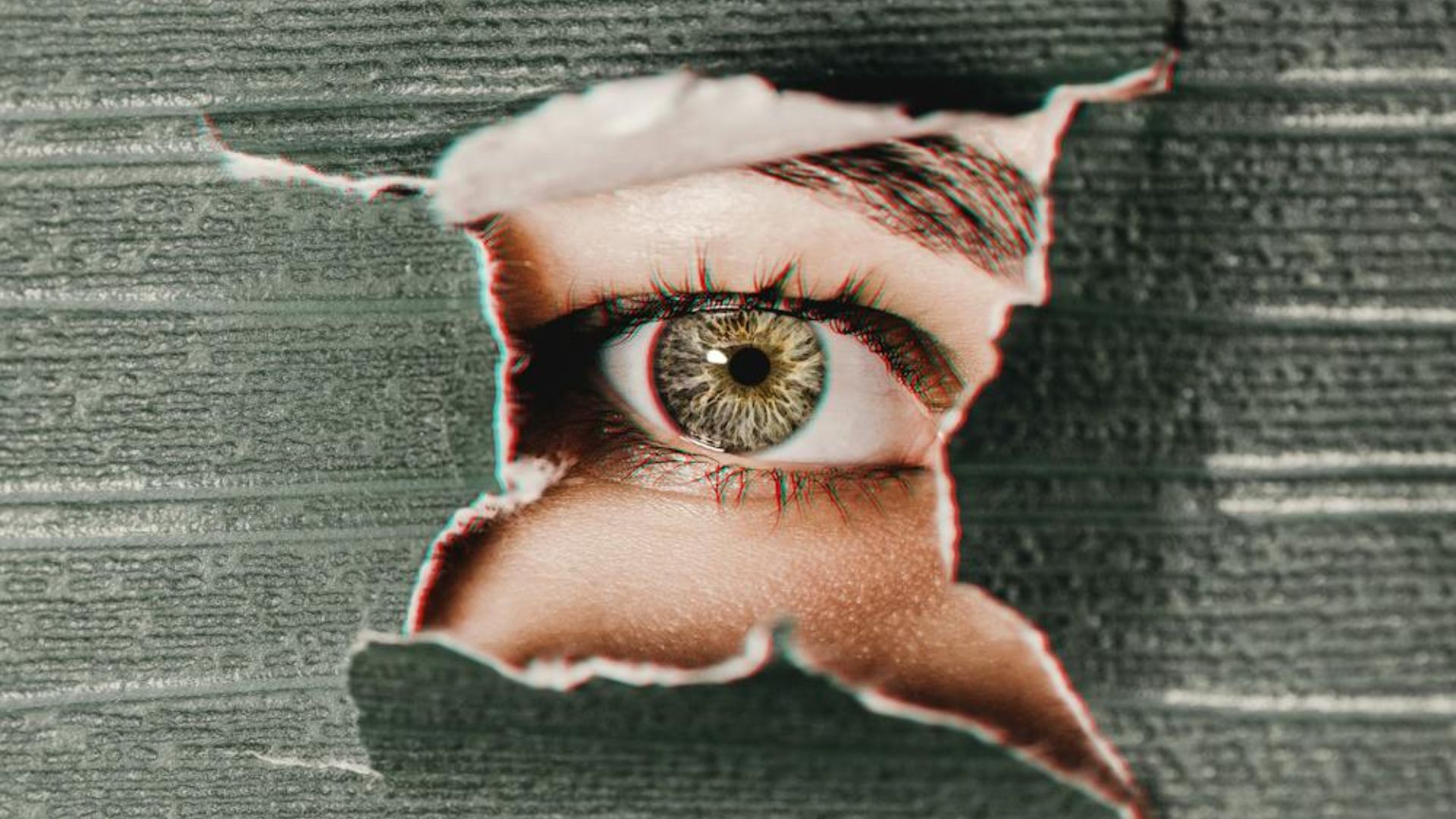 An eye looking at you through a broken wall.