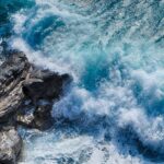 The view from above of the waves hitting a rock. The ocean looks in disarray, just like the current political scene in the US.