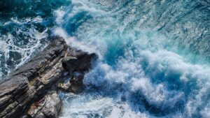 The view from above of the waves hitting a rock. The ocean looks in disarray, just like the current political scene in the US.