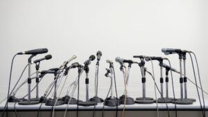 A bunch of microphones in a line, as if they were on a press conference, representing the comeback of Help a Reporter Out (HARO)