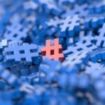 A bunch of blue hashtag/number symbols bunched up together with one red one in the middle.