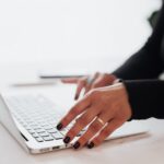 A lady writing on her computer as if she is working on SEO for her site.