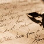An ink pen laying on top of an old looking paper with text written in cursive as an illustration of text content being created before the Claude Watermark and AI itself.